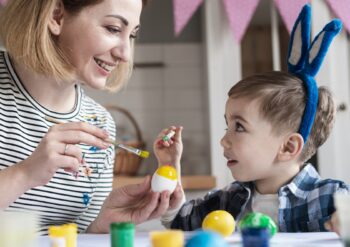 blonde-mother-teaching-her-son-how-paint-eggs-easter